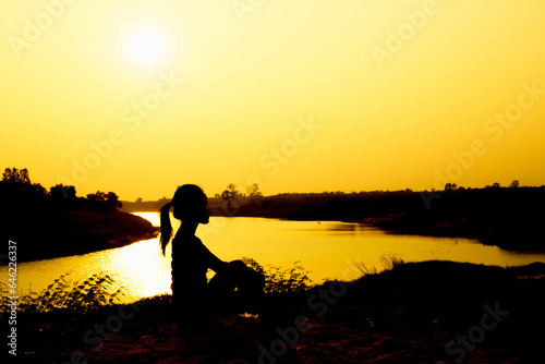 Silhouette of woman praying over beautiful sky background 