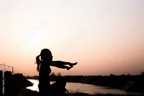 Silhouette of woman praying over beautiful sky background 