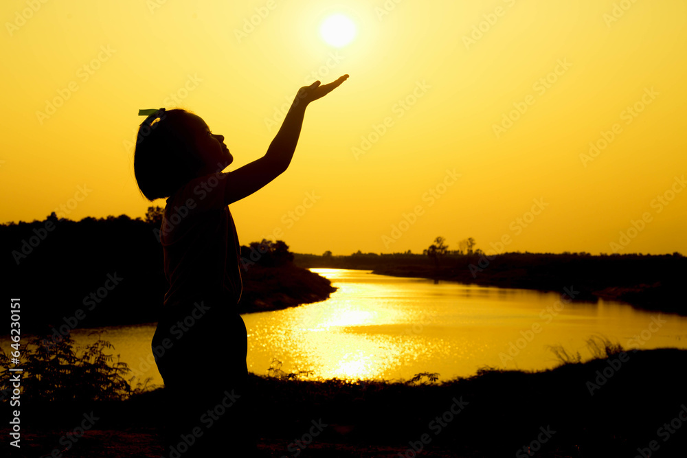 Fototapeta premium Silhouette of a family comprising a father, mother and two children happy family the sunset.Concept of friendly 