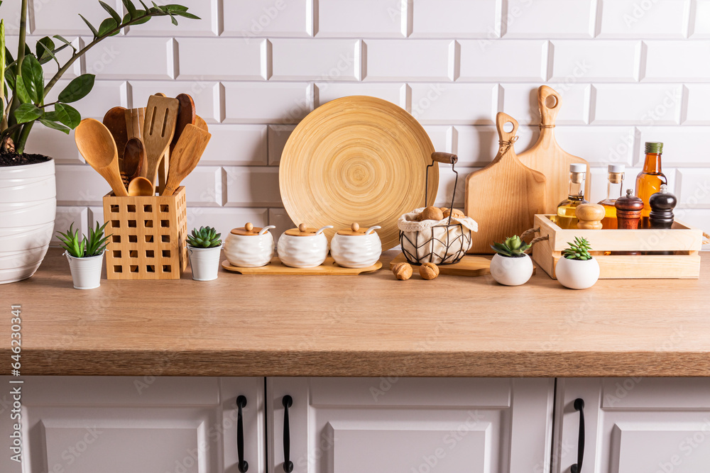 Beautiful stylish background of a modern kitchen wooden countertop with a set of eco-friendly utensils. front view. White brick wall.