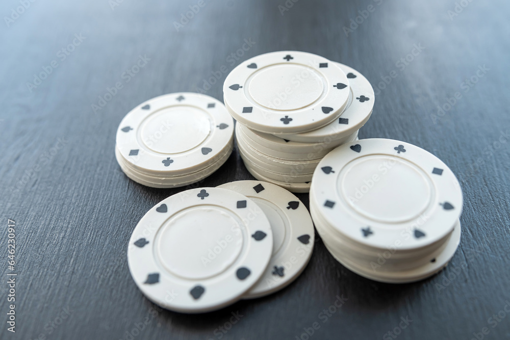Group of white chips for poker at dark table Group of white chips for poker at dark table