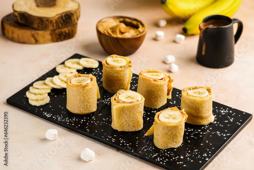 Healthy banana Crepe roll with chocolate served in dish isolated on table top view of cafe food dessert photo