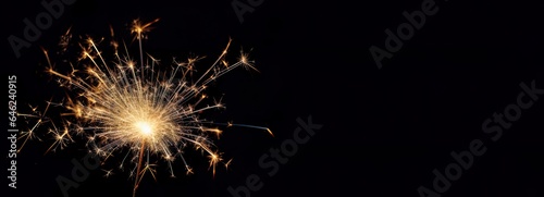 A magic explosion of sparks on a dark background. Sparkler glowing  burning  light. Celebrate a small firework in the night for fairy birthday  New Year and party.