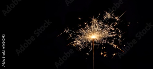 A magic explosion of sparks on a dark background. Sparkler glowing  burning  light. Celebrate a small firework in the night for fairy birthday  New Year and party.