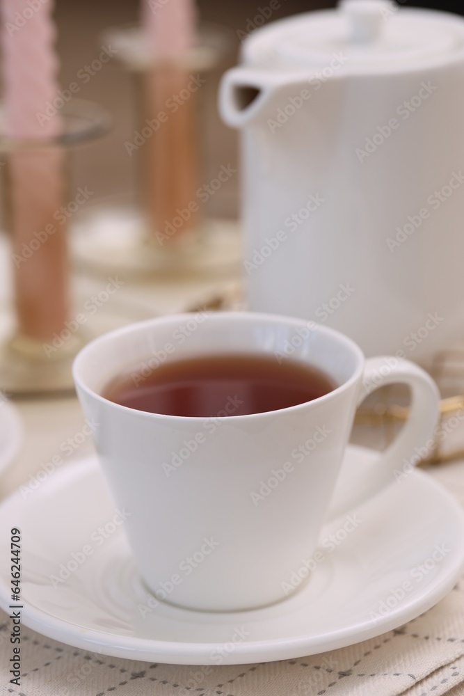 Cup of tea and teapot on white table, closeup Cup of tea and teapot on white table, closeup