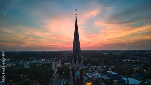 The silhouette of the cross and church bell tower in sunrise, sunset time. Aerial shot