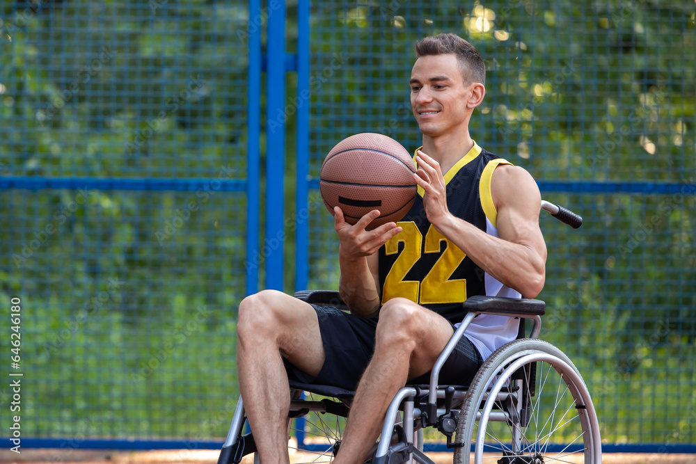 Young man in wheelchair playing basketball outdoor.