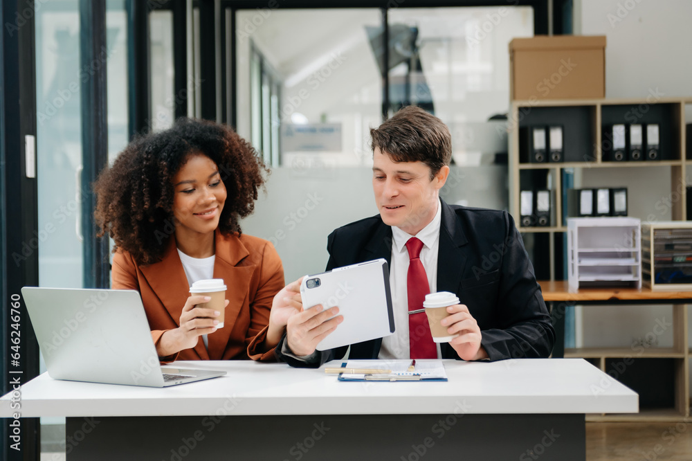 Businesswomen work and discuss their business plans. A Human employee explains and shows her colleague the results paper in modern office. Businesswomen work and discuss their business plans. A Human employee explains and shows her colleague the results paper in modern office.