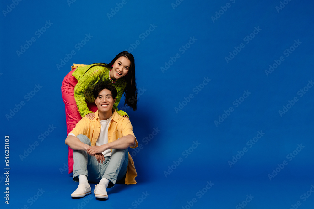 Young asian couple posing isolated over blue background Young asian couple posing isolated over blue background