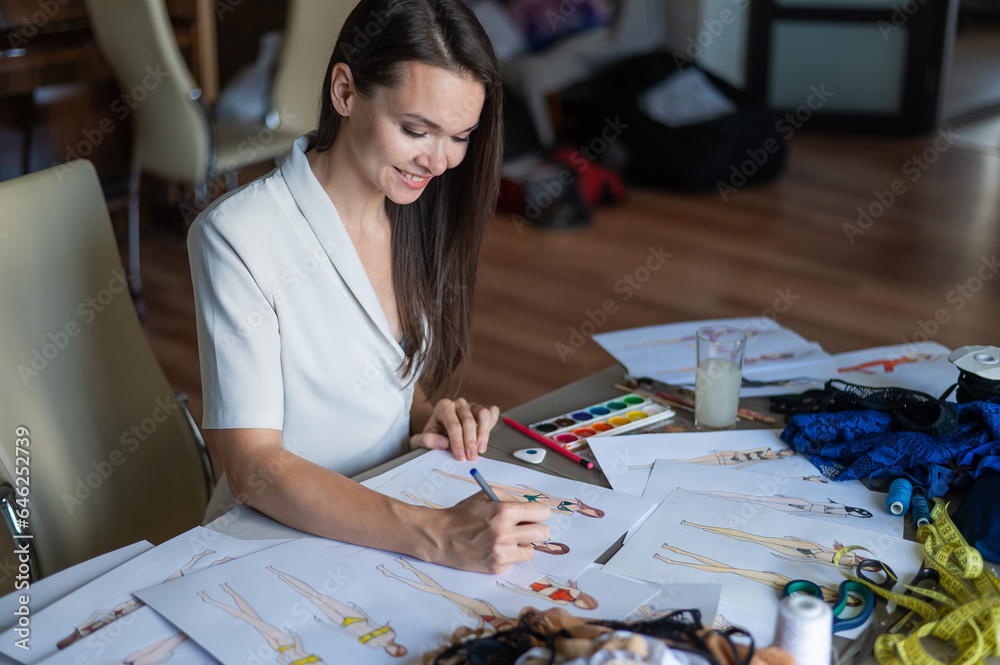 Fototapeta premium Woman drawing sketches of swimwear and underwear in watercolor.