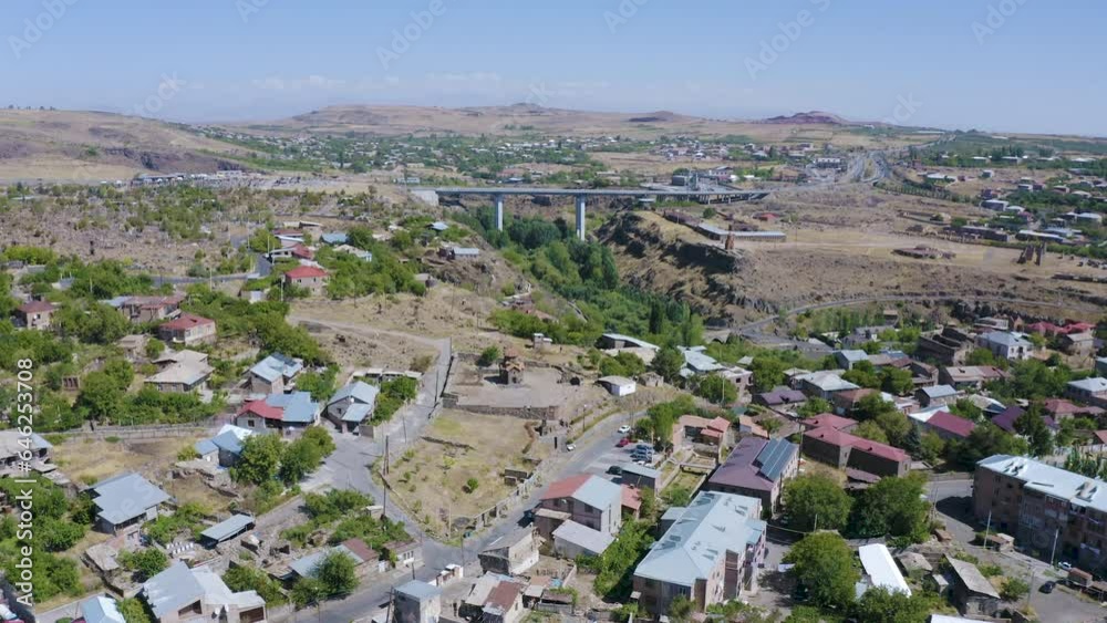 Forward reveal aerial shot of Ashtarak town and bridges over Kasakh river on sunny summer day. Aragatsotn Province, Armenia.