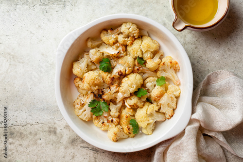 Oven roasted cauliflower in a casseroule. Top view. Vegan meal.