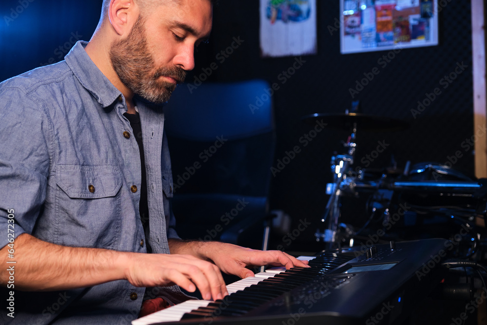 Musician man playing keyboard synthesizer piano in a recording studio. Music production. Musician man playing keyboard synthesizer piano in a recording studio. Music production.