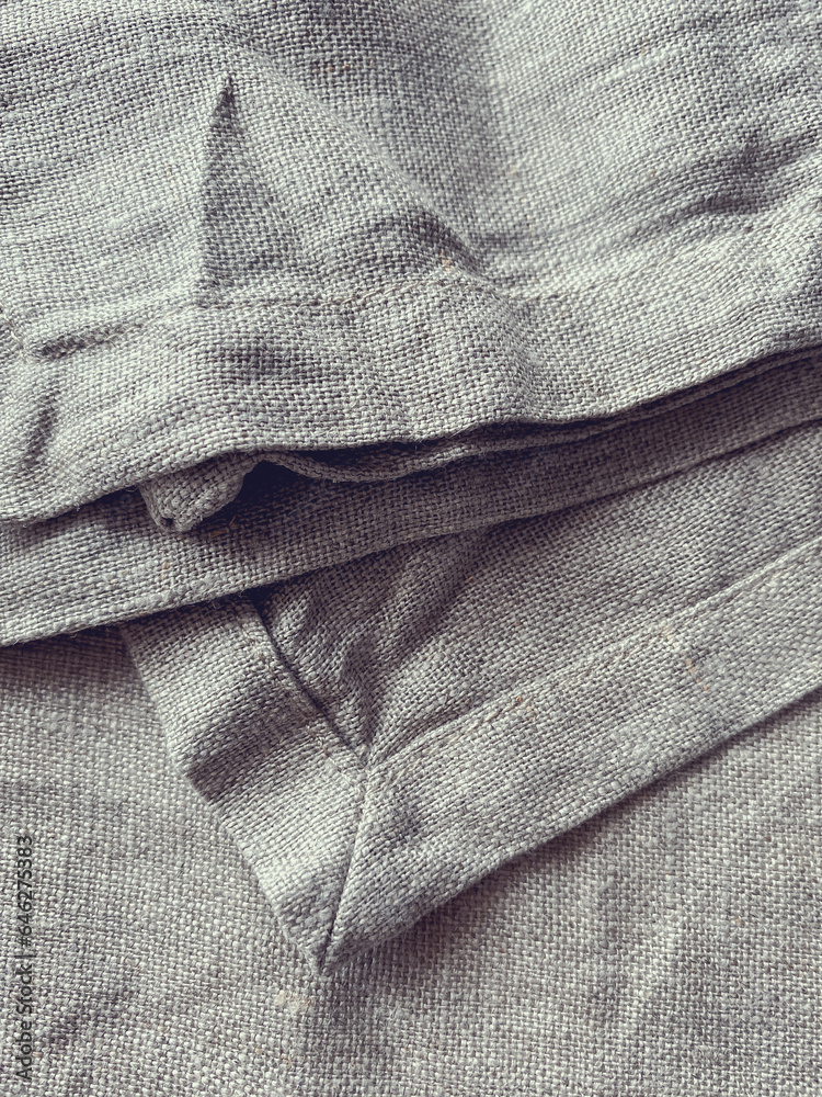 Fototapeta premium The texture of natural linen fabric. Linen textile background, top view. Rough crumpled burlap. Napkin made of natural linen.