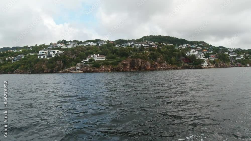 Boat Trip with Scenic Views Passing By with Rural Homes Overlooking the Waters near Bergen, Norway. Boat Trip with Scenic Views Passing By with Rural Homes Overlooking the Waters near Bergen, Norway.