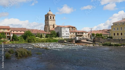 Church in the center of town seen from the mighty river on a summer day. Aguilar de Campoo, Spain photo