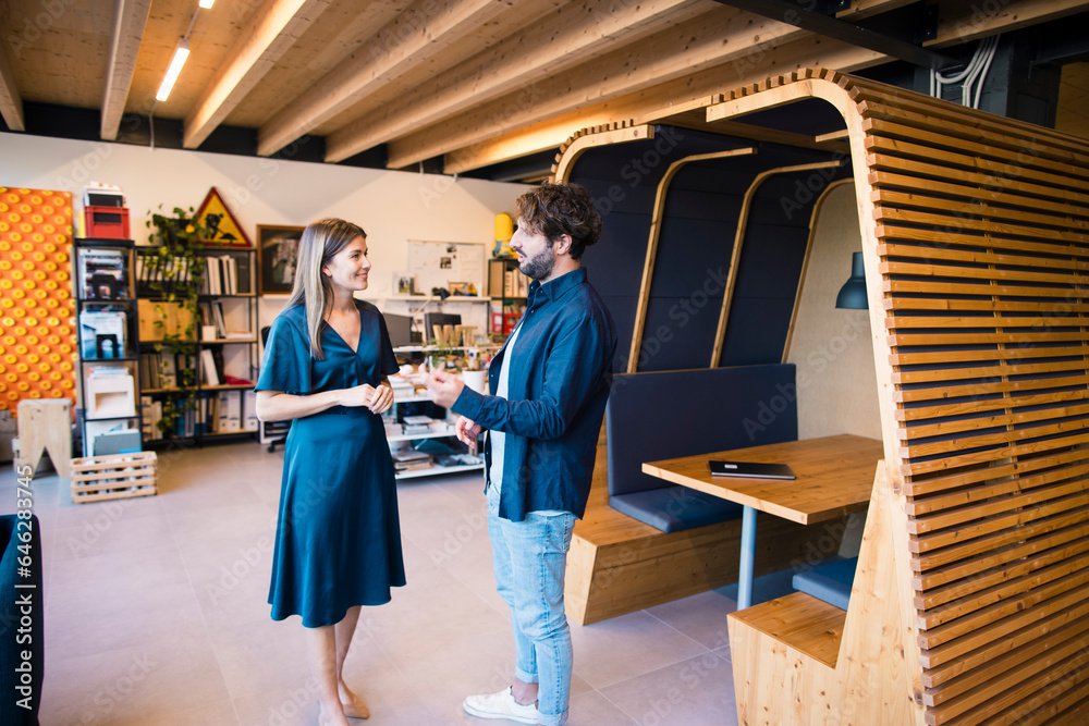 Smiling business people standing in office discussing