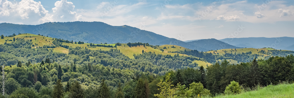 panorama of green mountains covered with green forest and hills.