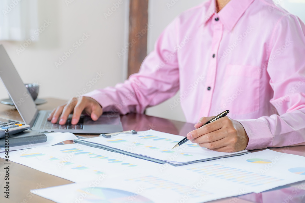 Businessmen bookkeeper hand holding pen doing account for paying tax in working office Businessmen bookkeeper hand holding pen doing account for paying tax in working office