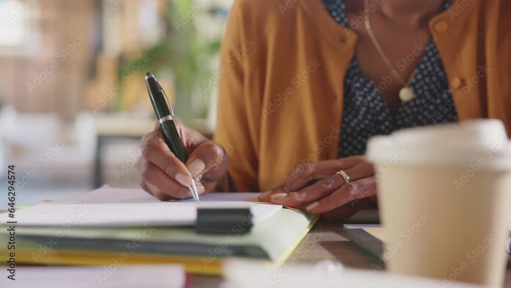 Detail of black woman hands writing on paperwork