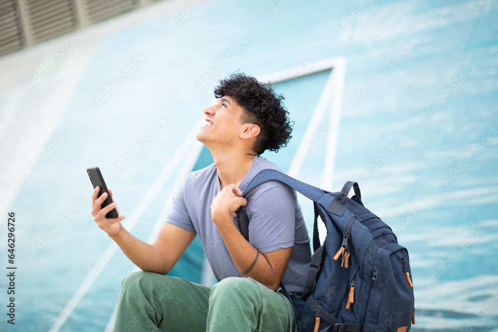 happy young man holding mobile phone and bag happy young man holding mobile phone and bag