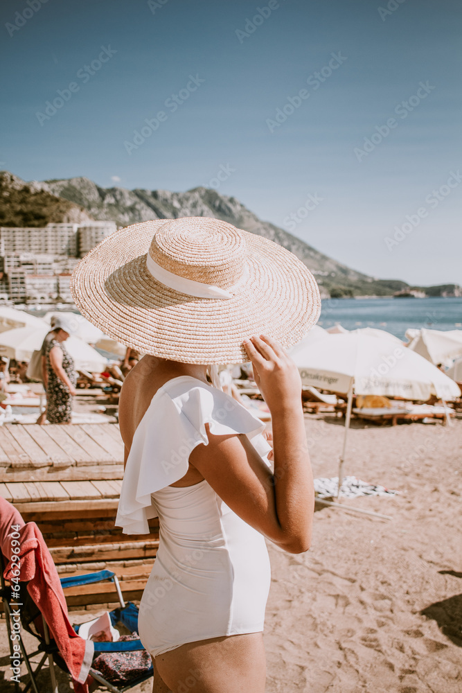 Stylish woman in summer hat at the beach