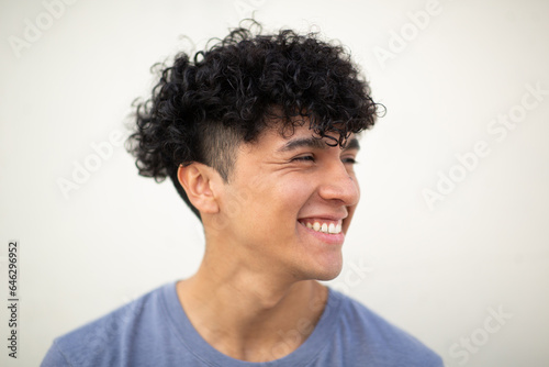 Close up smiling young man against white background looking away