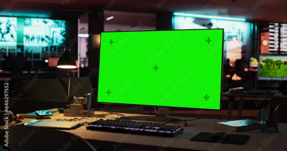 Empty Office of Creative Agency with Art on Walls and Desks with Computers. Office Space with Digital Green Screen Mock Up Chroma Key Monitor Standing at Night on Developer's Table. Zoom Out Empty Office of Creative Agency with Art on Walls and Desks with Computers. Office Space with Digital Green Screen Mock Up Chroma Key Monitor Standing at Night on Developer's Table. Zoom Out