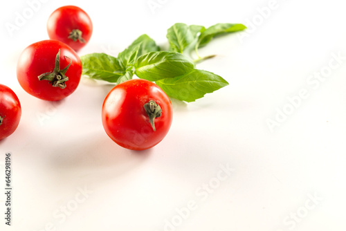 Fototapeta Naklejka Na Ścianę i Meble -  ripe juicy tomatoes and basil leaves on the table
