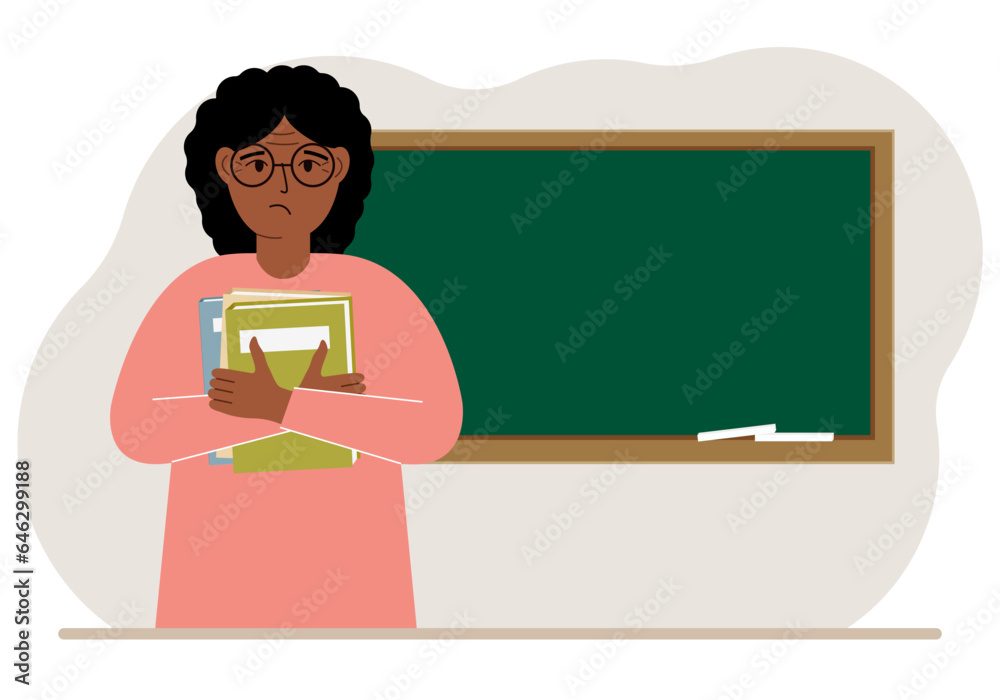 Female teacher with books on the background of the school board.