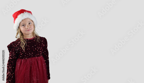 Christmas concept with a beautiful little girl with a Santa hat on a white background, A place for your text.