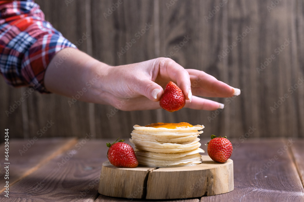 Stack of freshly prepared traditional pancakes with strawberries Stack of freshly prepared traditional pancakes with strawberries