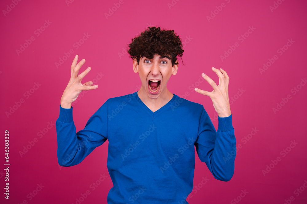 Young attractive curly man posing on a pink background. Young attractive curly man posing on a pink background.