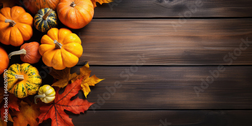 Autumn leaves and pumpkins on wooden background with copyspace
