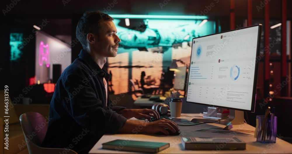 Talented Male Digital Marketing Specialist Working on Computer at Office in the Evening. Young Caucasian Businessman in Creative Agency, Smiling and Researching Business Analytical Data