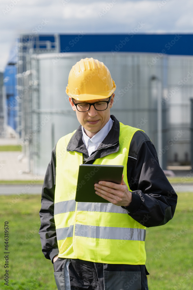 Engineer with digital tablet on a background of gas tanks. Engineer with digital tablet on a background of gas tanks.