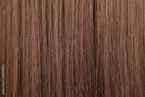Close-up view of natural shiny brown hair, bunch of brunette curls background