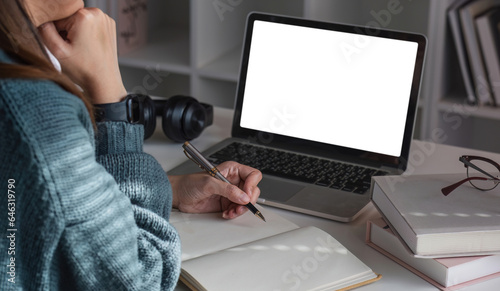 Asian girl watch studying online using applications, app, e learning distance training course at home. Over shoulder view on mockup image on laptop computer with white screen.