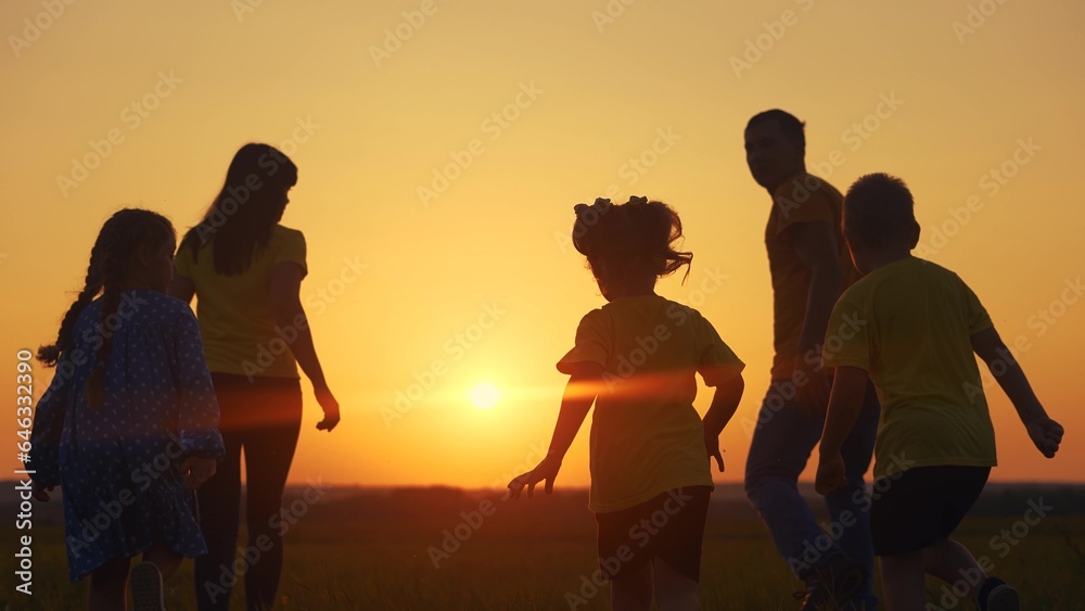 happy family in the park. a group of children running silhouette and parents in nature in the park at sunset. happy sun family kid dream concept. friendly family lifestyle runs silhouette in the park