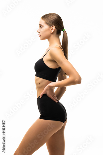 Laughing sporty woman in black bikini posing on grey background. Photo of attractive girl with slim toned body.