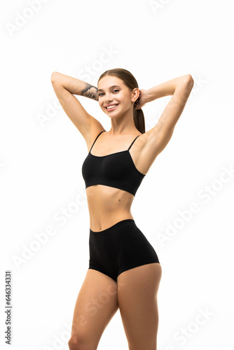 Smiling sporty woman in black underwear posing on studio background with copy space. Female beauty, sport, spa concept
