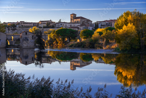 Obraz na płótnie View of the city of Zamora and watermills and the San Pedro Church in the background in autmn at sunset reflected in the Duero river