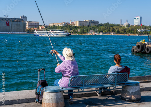 A woman fishing on the beach of Kadıköy in Istanbul