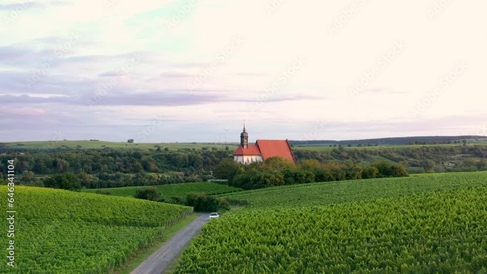 drone flight just above the vineyards to a small church in the light of the evening sun drone flight just above the vineyards to a small church in the light of the evening sun