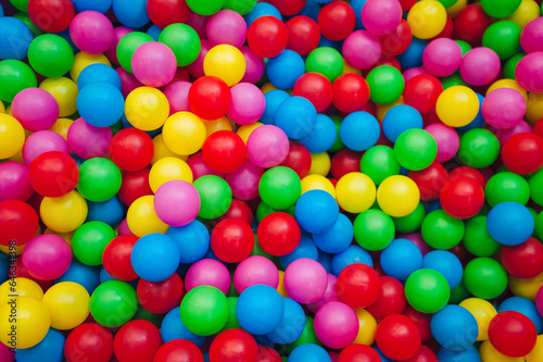 Top view of many multicolored plastic balls in a ball pool at a children's indoor playground. Recreation and entertainment concept. photo