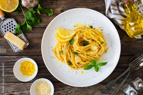 Linguine al limone - pasta with lemon and parmesan on wooden background 