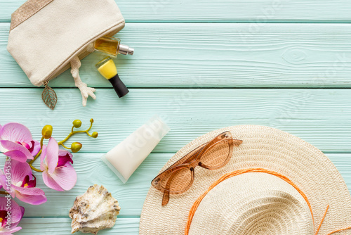 Beach accessoties with sunscreen cosmetic and straw hat. Summer beach concept flatlay photo