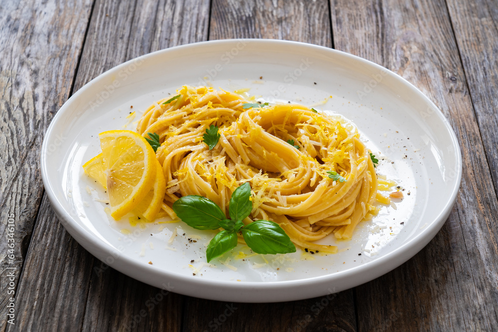 Linguine al limone - pasta with lemon and parmesan on wooden background
Linguine al limone - pasta with lemon and parmesan on wooden background