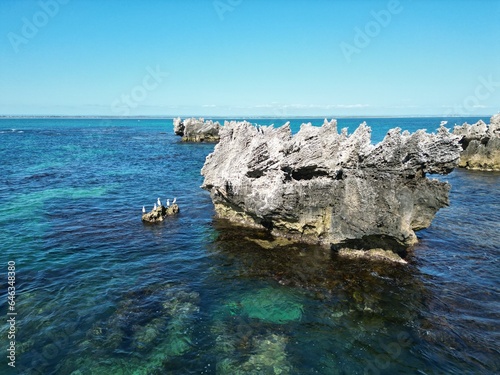 Rocks in the ocean on a clear sunny day with beautiful clear blue water with reefs