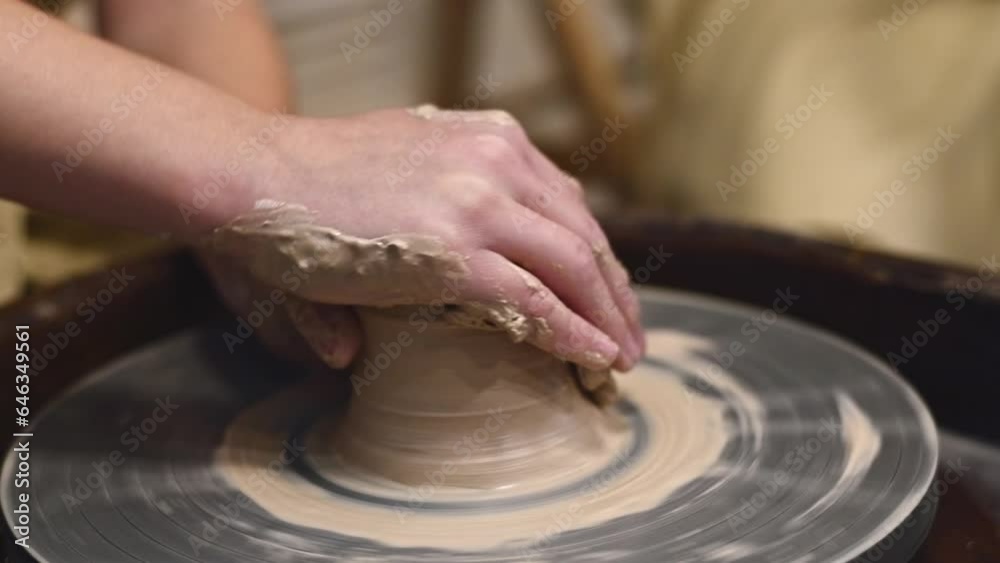 Potter girl works on potter's wheel, making ceramic pot out of clay in pottery workshop. Art and hobby concept. slow motion Potter girl works on potter's wheel, making ceramic pot out of clay in pottery workshop. Art and hobby concept. slow motion